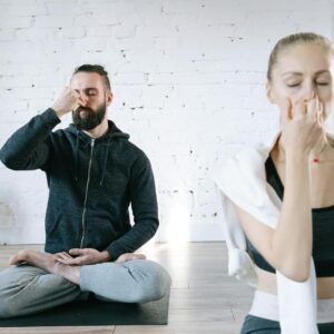 man in blue zip up jacket sitting beside woman in white long sleeve shirt