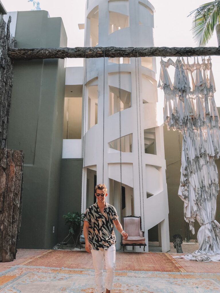 woman in black and white floral dress standing beside white concrete building during daytime